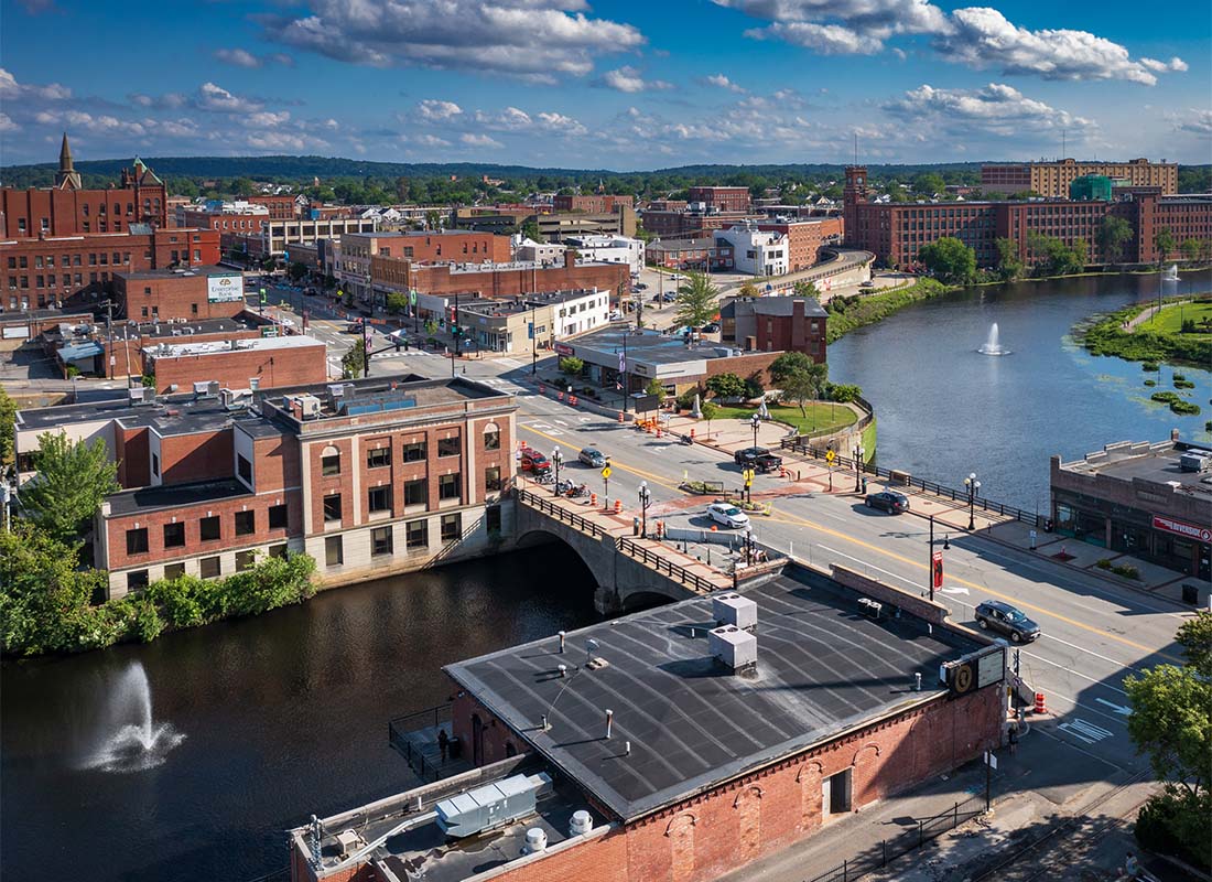 Nashua, NH - Aerial View of a Bridge with Views of the River on Both Sides and Historical Buildings Along Main Street in Downtown Nashua New Hampshire on a Sunny Day
