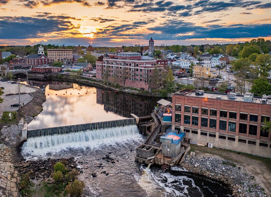 Service Center - Aerial View of a Waterfall Next to Historical Buildings on the River in Nashua New Hampshire at Sunset